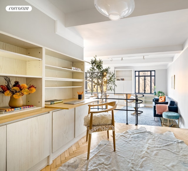 sitting room featuring parquet flooring and beamed ceiling