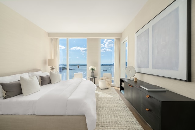 50 Bridge Park Dr Unit 25Ae, New York City, NY 11201 - bedroom with access to exterior, a water view, and wood finished floors