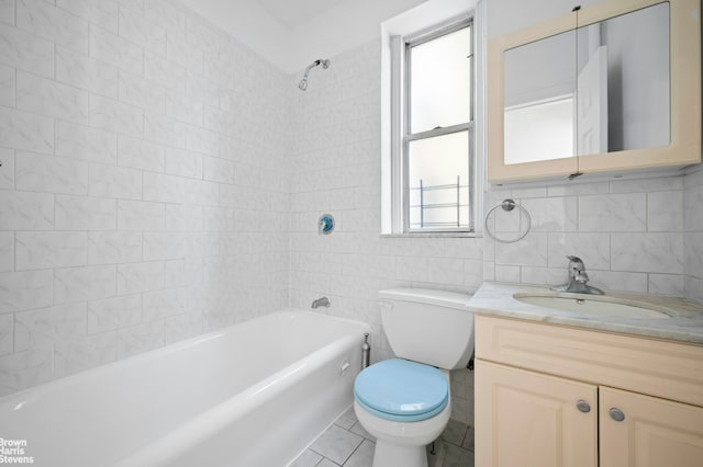 bathroom with tile walls, toilet, vanity, shower / washtub combination, and tile patterned floors