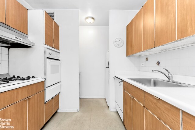 kitchen with sink, white appliances, and tasteful backsplash