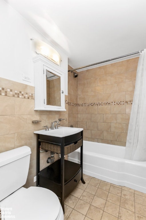 bathroom with tile walls, toilet, shower / bath combo, and tile patterned flooring