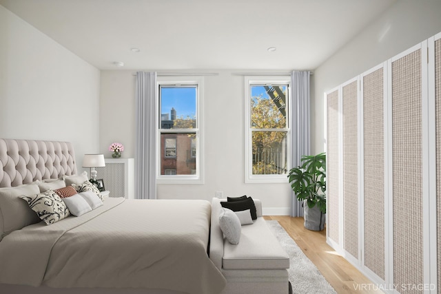 bedroom featuring baseboards and light wood finished floors