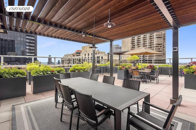 view of patio featuring outdoor dining area and a city view