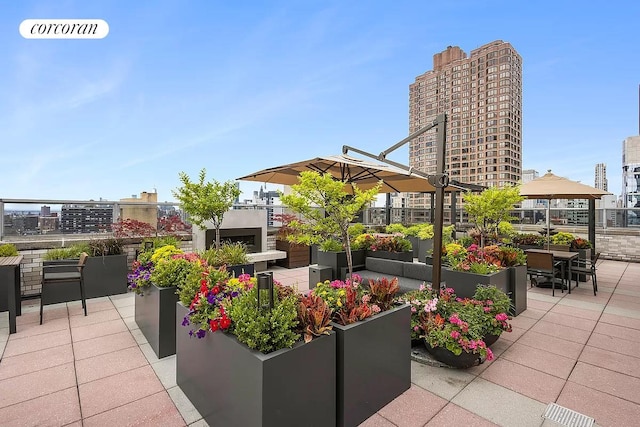 view of patio / terrace featuring visible vents, a city view, and a vegetable garden