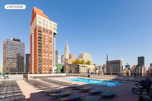 pool with a view of city and a patio area