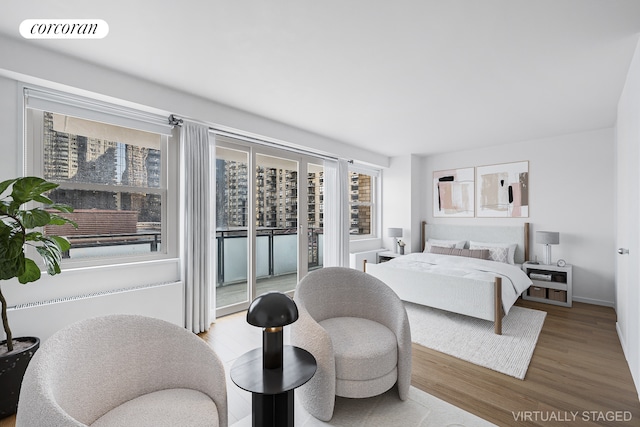 bedroom with access to exterior, wood finished floors, and visible vents