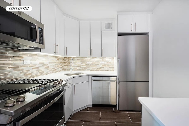 kitchen featuring visible vents, backsplash, stainless steel appliances, white cabinetry, and a sink