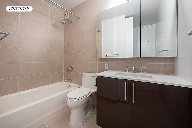 full bathroom with toilet, vanity,  shower combination, tile walls, and tile patterned floors