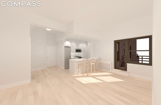 unfurnished room with light wood-style flooring and baseboards