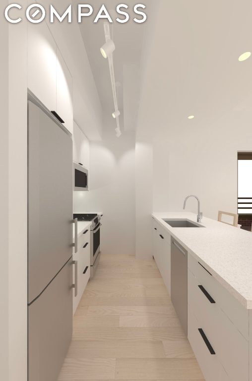 kitchen featuring a peninsula, white cabinetry, stainless steel appliances, and a sink