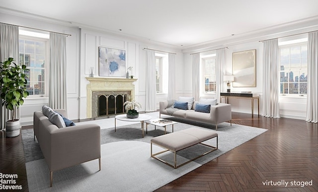 living room featuring ornamental molding, plenty of natural light, a high end fireplace, and dark parquet floors