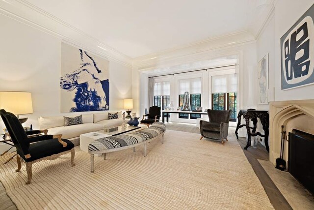 living room featuring crown molding, wood-type flooring, and a fireplace