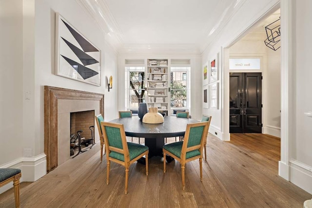 dining space featuring hardwood / wood-style floors and ornamental molding