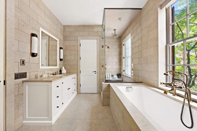 bathroom featuring vanity, shower with separate bathtub, and tile walls