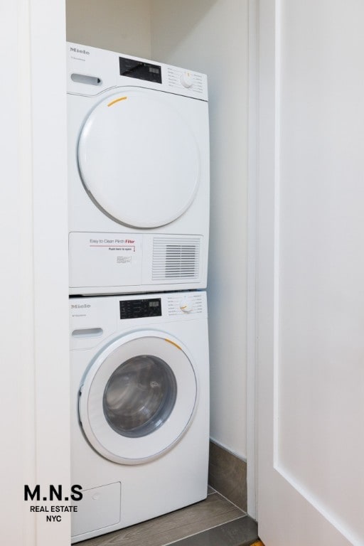 clothes washing area featuring stacked washing maching and dryer