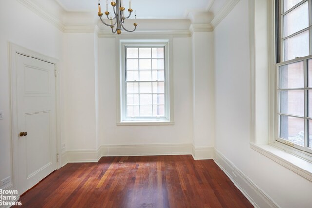 living room featuring an inviting chandelier, dark hardwood / wood-style flooring, crown molding, and a tile fireplace