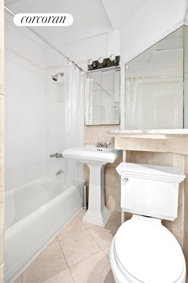 bathroom featuring tile walls, shower / bath combo with shower curtain, toilet, and tile patterned floors