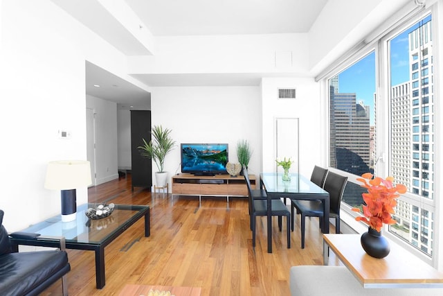 living area featuring light wood-style floors and visible vents