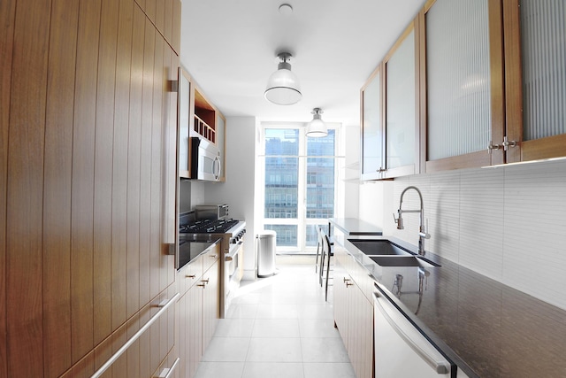 250 E 53rd St Unit 3302, New York City, NY 10022 - kitchen featuring a sink, dishwasher, decorative backsplash, high end range, and dark countertops