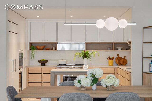 kitchen with under cabinet range hood, open shelves, backsplash, and oven