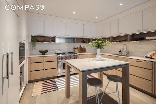 kitchen featuring a sink, high end stainless steel range oven, open shelves, and light countertops