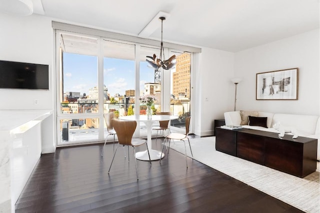 dining area with dark hardwood / wood-style flooring, a wealth of natural light, an inviting chandelier, and floor to ceiling windows