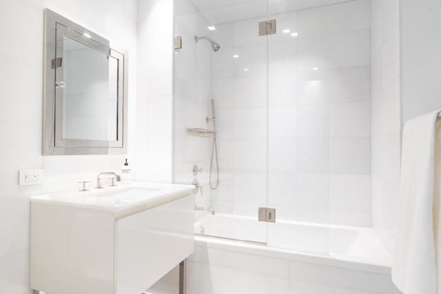 bathroom featuring combined bath / shower with glass door and vanity