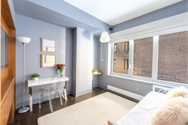 bedroom featuring a baseboard heating unit and dark hardwood / wood-style floors