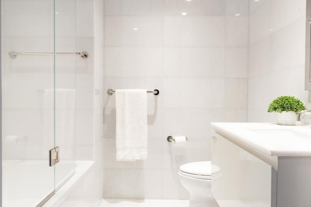 bathroom featuring an enclosed shower, vanity, and toilet