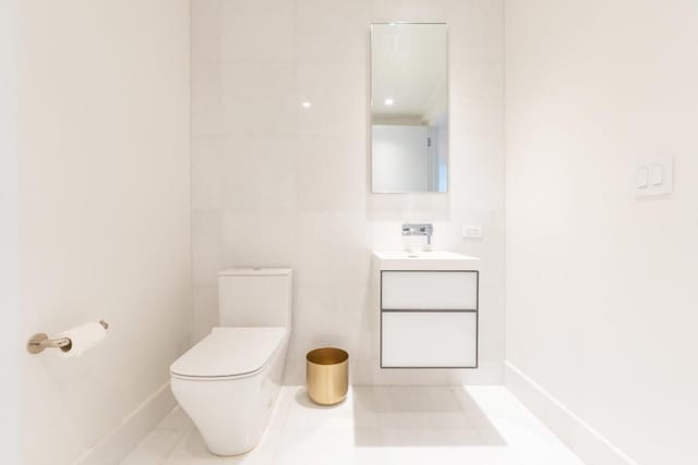 bathroom featuring tile walls, toilet, and vanity