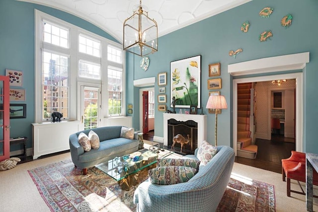 45 E 9th St Unit 45, New York City, NY 10003 - living area with a fireplace, a notable chandelier, baseboards, a towering ceiling, and carpet floors