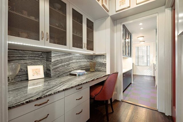 dining space with wood-type flooring, a chandelier, and beamed ceiling