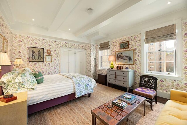 45 E 9th St Unit 45, New York City, NY 10003 - bedroom with beamed ceiling, a closet, wallpapered walls, and wood finished floors