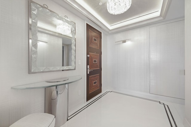 bathroom with an inviting chandelier and a raised ceiling