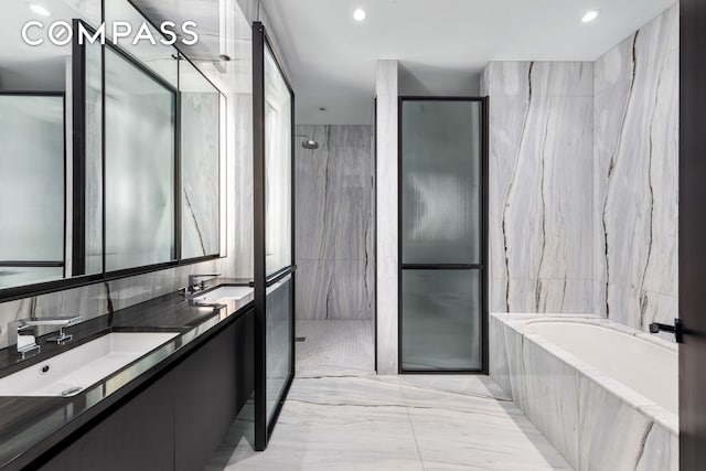 full bathroom featuring a sink, a walk in shower, tile walls, and a bath