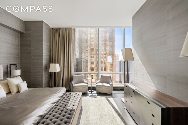 bedroom featuring wood finished floors and floor to ceiling windows