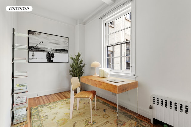 unfurnished living room featuring beam ceiling and light hardwood / wood-style floors