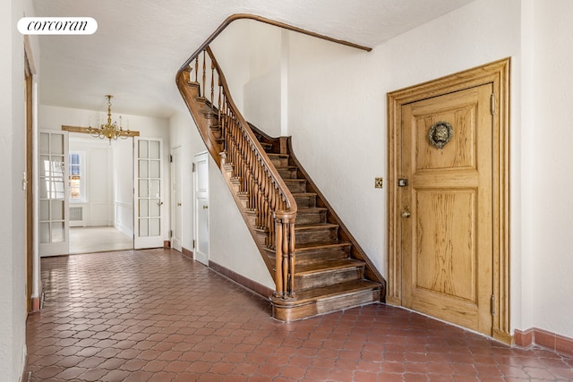 stairway featuring a chandelier and french doors