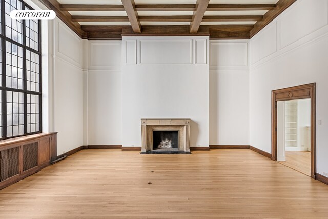 dining area with beam ceiling, ornamental molding, built in features, and light hardwood / wood-style floors