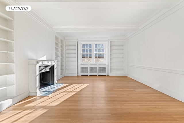 unfurnished living room featuring crown molding, built in features, a premium fireplace, radiator heating unit, and beamed ceiling