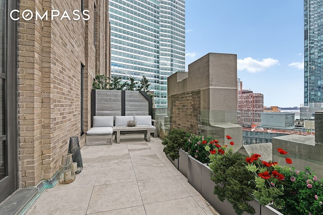 view of patio / terrace with an outdoor living space, a view of city, and a balcony