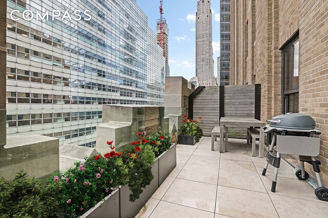 view of patio / terrace featuring a city view and grilling area