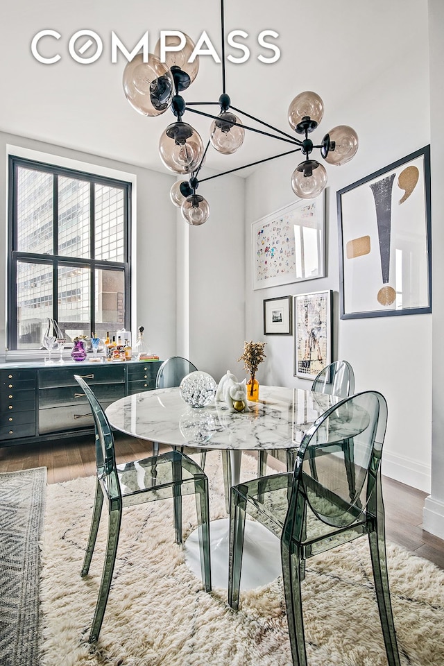 dining space with baseboards and wood finished floors