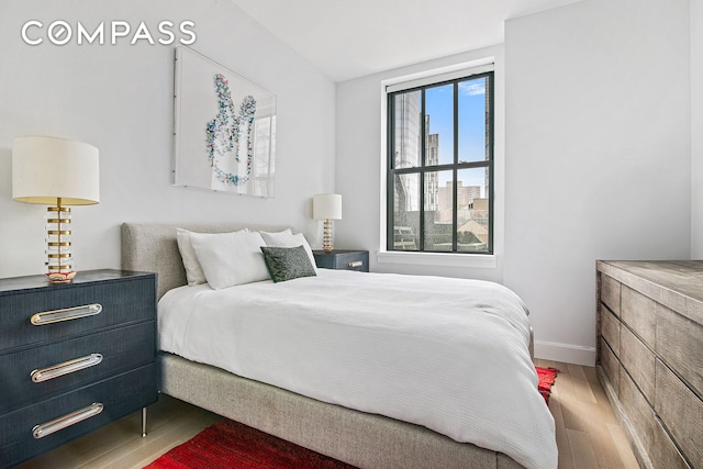 bedroom with wood finished floors and baseboards