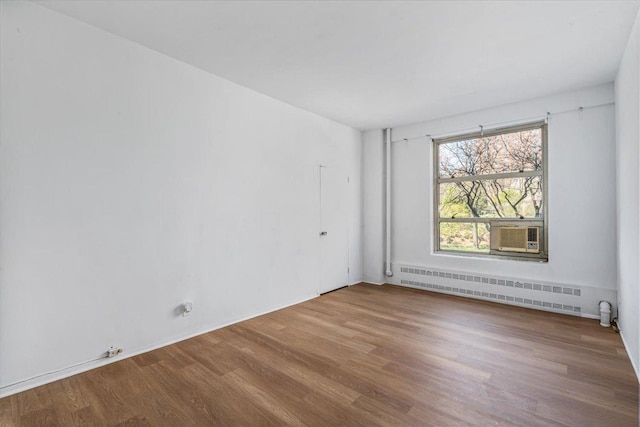 501 W 123rd St Unit 3A, New York City, NY 10027 - unfurnished room with radiator heating unit, wood finished floors, and cooling unit
