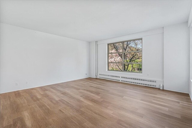 501 W 123rd St Unit 3A, New York City, NY 10027 - spare room with baseboard heating and wood finished floors