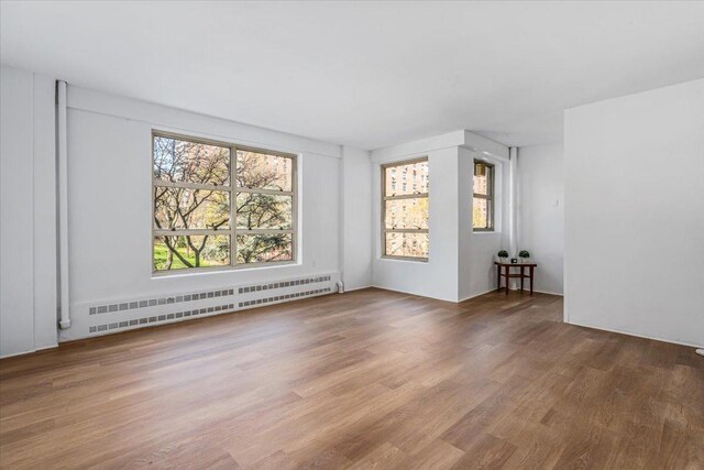 501 W 123rd St Unit 3A, New York City, NY 10027 - spare room featuring a baseboard radiator and wood finished floors