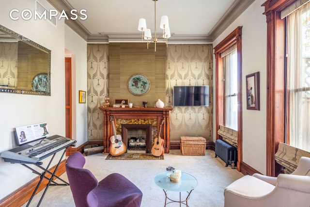 living room with ornamental molding, radiator heating unit, carpet floors, a fireplace, and a chandelier