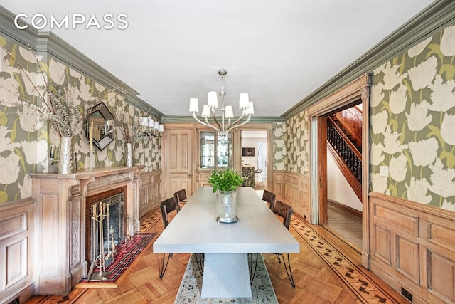 dining room with crown molding, a high end fireplace, and light parquet floors