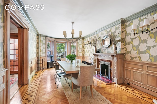 dining area with a wainscoted wall, wallpapered walls, and ornamental molding